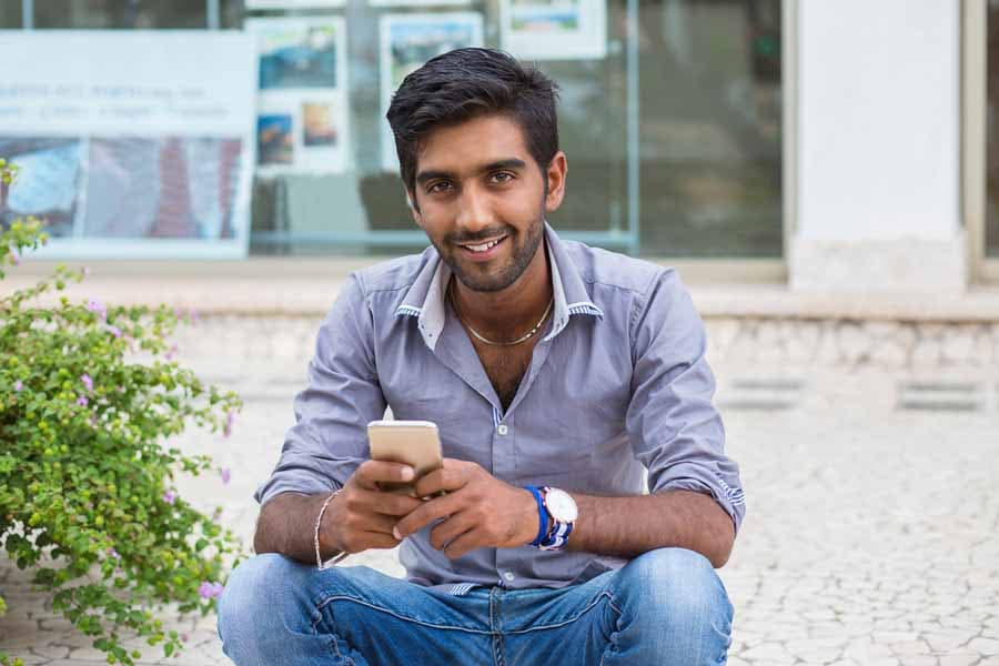 A man holding his phone while sitting