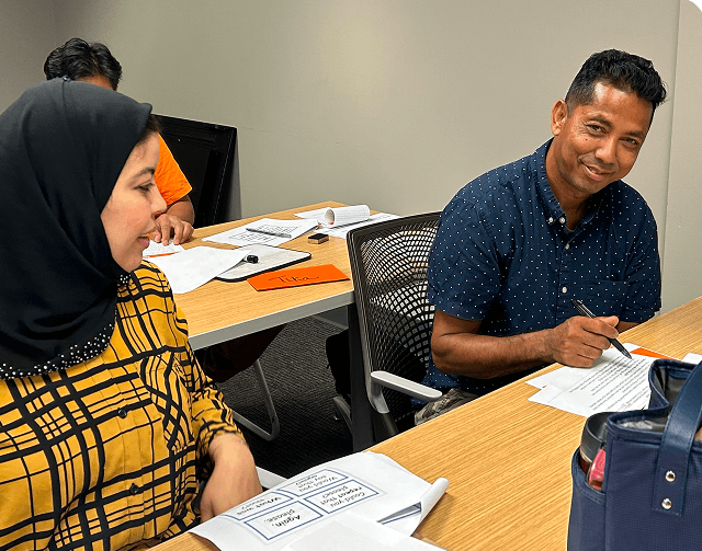 Employees collaborating during a real workplace language training session