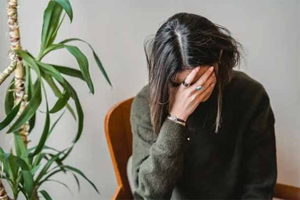 A woman holding her head down